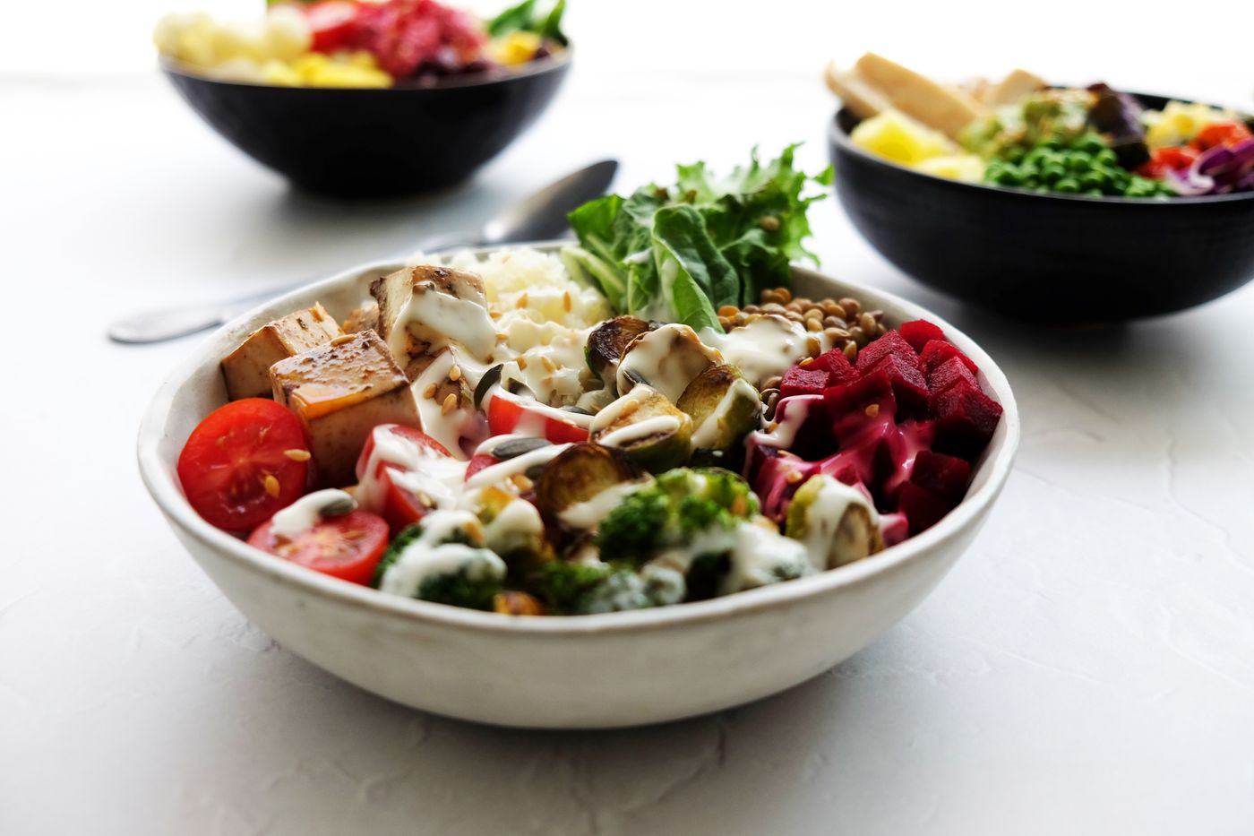 Freshly prepared bowls of vegetables, grains, and greens